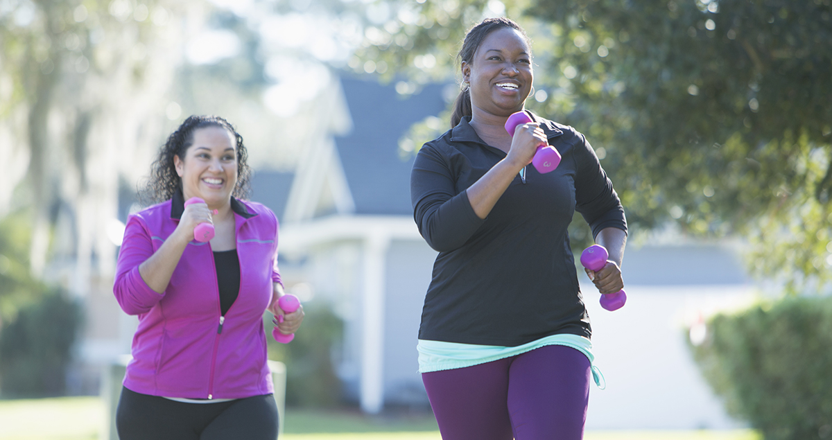 African American woman and friend running with dumbbells